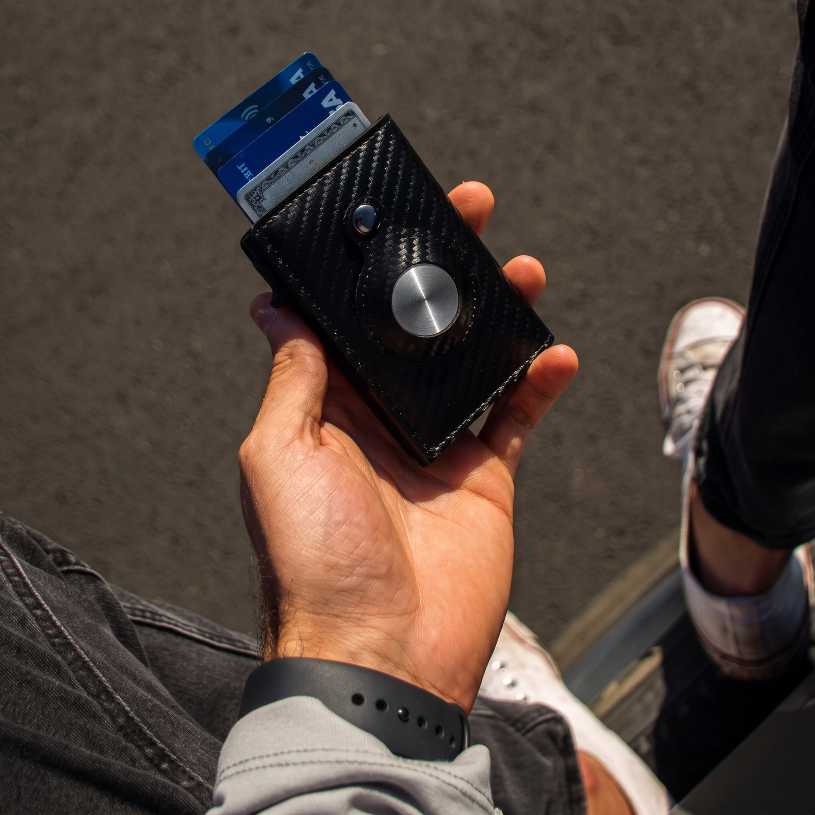 AirTag Slide Wallet in hand with cards fanned out