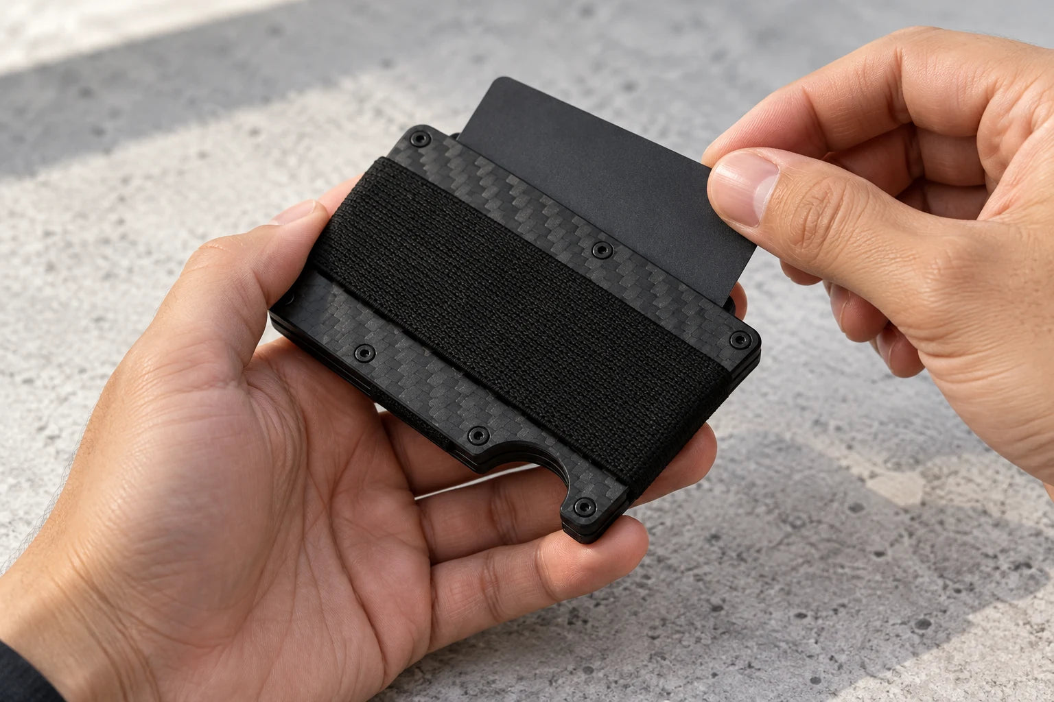 A card being taken from an aluminum Slim Wallet in the Carbon Fiber finish